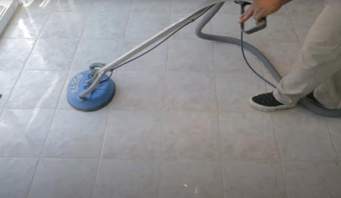 cleaning a tiled floor with a floor scrubber