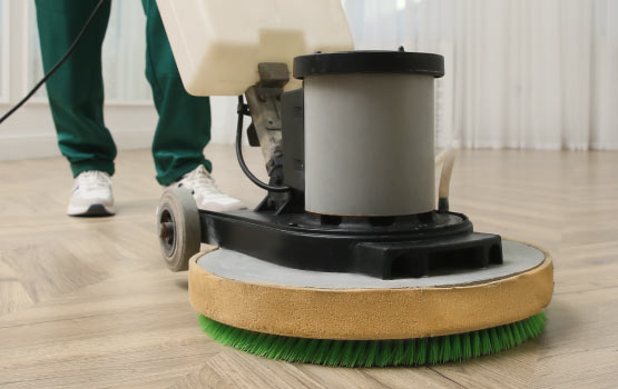 Close-up of a professional floor cleaning machine on a travertine floor.